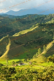 Sunlit hills with shadows and a small settlement