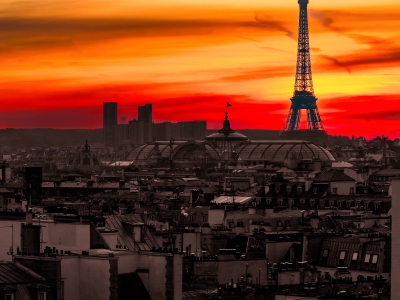 Striking Eiffel Tower silhouette against a fiery sunset sky over Paris rooftops