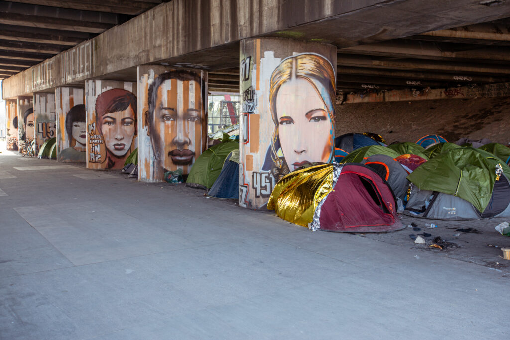 Quechua tents pitched near the graffiti wall at Quai de l'Allier, illustrating the cultural and social diversity of the area